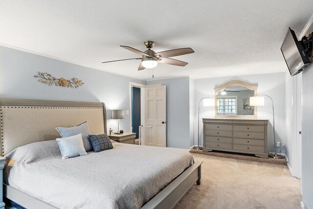 carpeted bedroom featuring ornamental molding and a ceiling fan