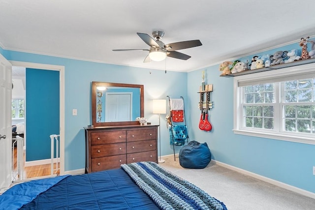 bedroom featuring multiple windows, ornamental molding, baseboards, and a ceiling fan