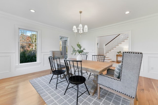 dining space featuring a notable chandelier, crown molding, and light hardwood / wood-style floors