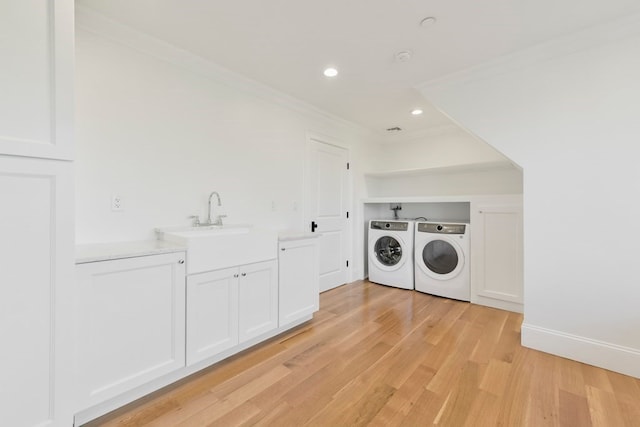 laundry room with sink, light hardwood / wood-style flooring, crown molding, and independent washer and dryer