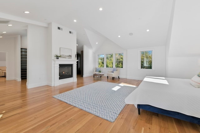 bedroom featuring high vaulted ceiling and light hardwood / wood-style floors