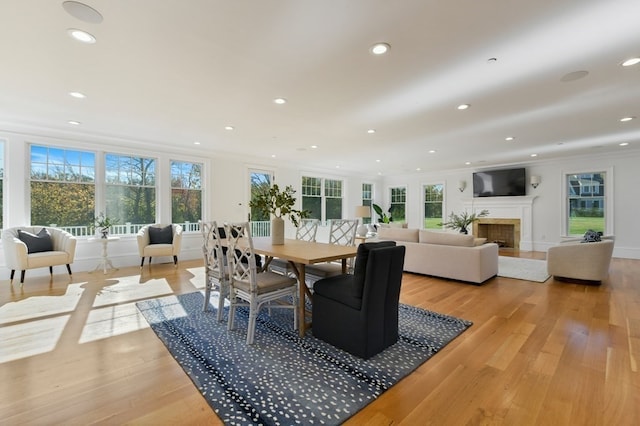 dining space with crown molding and light wood-type flooring