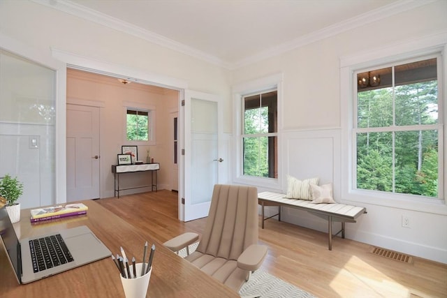 living area with light wood-type flooring and ornamental molding