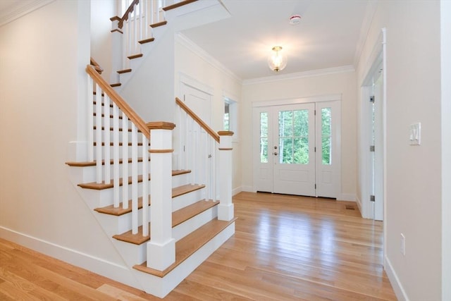 foyer entrance with light hardwood / wood-style flooring and crown molding