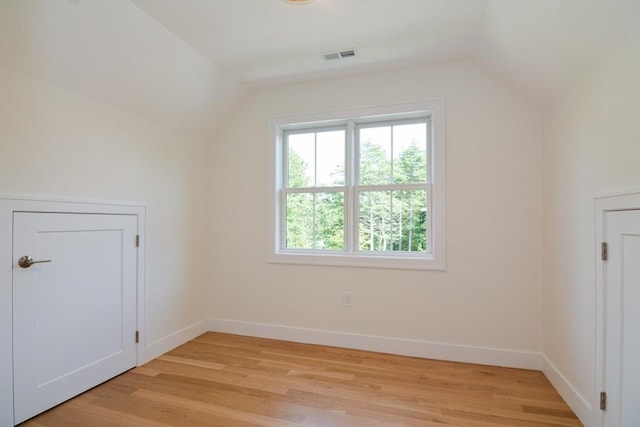 additional living space featuring light hardwood / wood-style flooring and vaulted ceiling