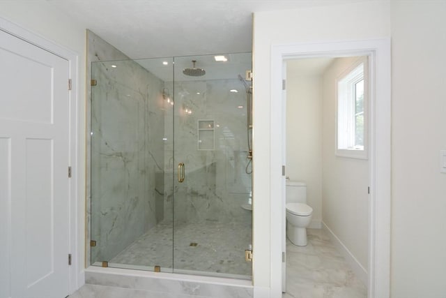 bathroom with toilet and a shower with shower door