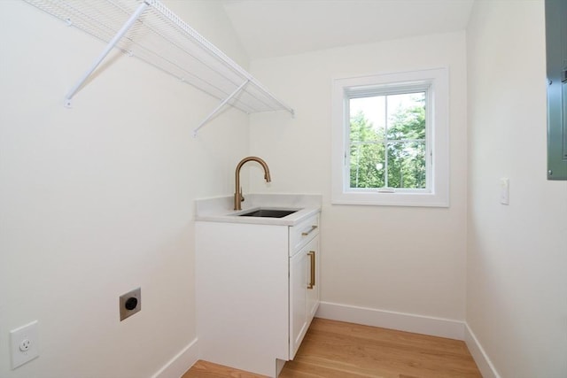 laundry area featuring sink, light hardwood / wood-style flooring, cabinets, and hookup for an electric dryer