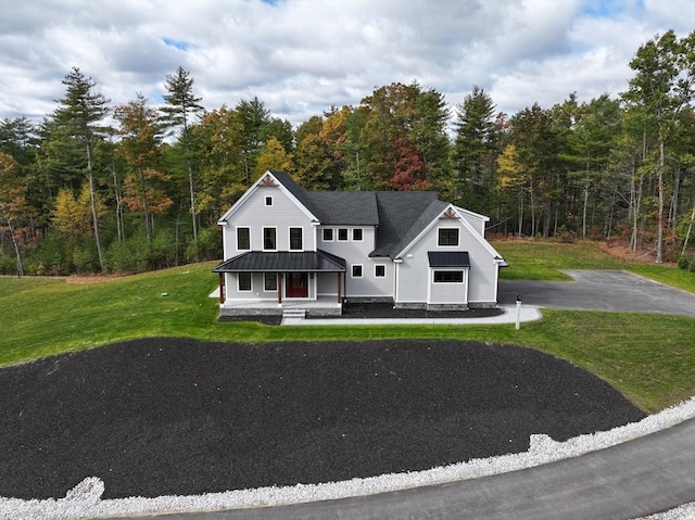 view of front of house with covered porch and a front lawn