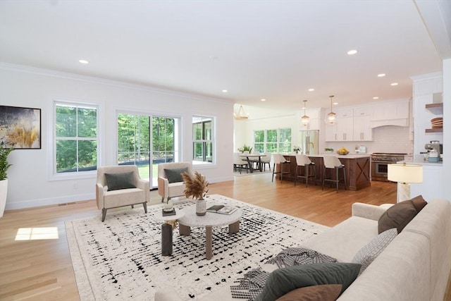 living room with ornamental molding and light hardwood / wood-style flooring