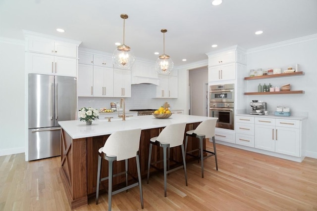 kitchen with backsplash, stainless steel appliances, white cabinetry, and hanging light fixtures