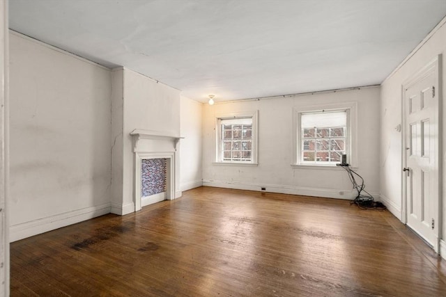 unfurnished living room featuring dark wood-type flooring, a fireplace, and baseboards