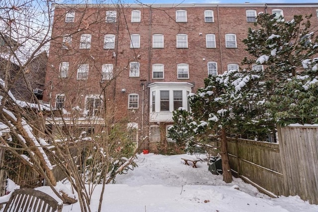 snow covered property featuring fence