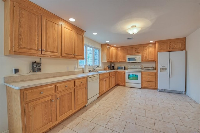 kitchen featuring light countertops, white appliances, a sink, and recessed lighting