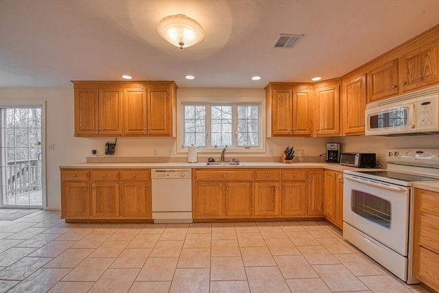 kitchen featuring white appliances, visible vents, light countertops, and a sink