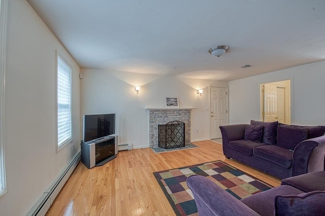 227 Village St, Millis, MA 02054 - living area with light wood-style floors, a fireplace, visible vents, and baseboard heating