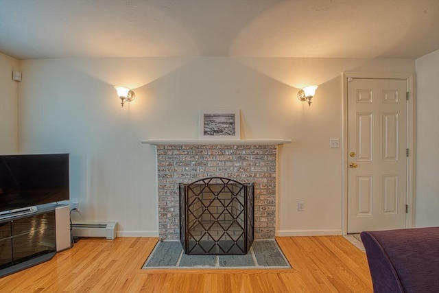 227 Village St, Millis, MA 02054 - living area with a baseboard radiator, a brick fireplace, baseboards, and wood finished floors