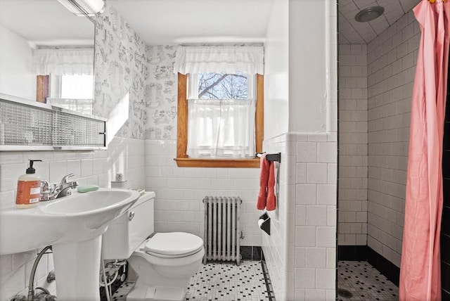 bathroom featuring tile patterned floors, a shower with curtain, tile walls, radiator heating unit, and toilet