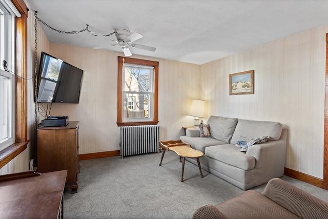 carpeted living room featuring ceiling fan and radiator heating unit