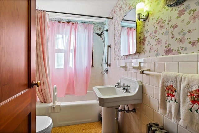 full bathroom featuring sink, toilet, tile walls, and shower / tub combo with curtain