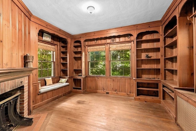 25 Hundreds Cir, Wellesley, MA 02481 - unfurnished office featuring wood walls, built in features, wood finished floors, a brick fireplace, and a textured ceiling