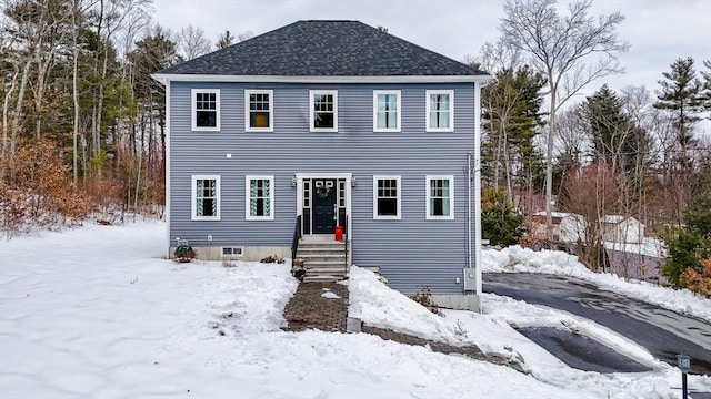 colonial home featuring a shingled roof