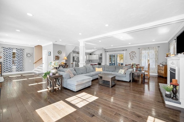 living area with dark wood-style floors, a fireplace, stairway, and ornamental molding