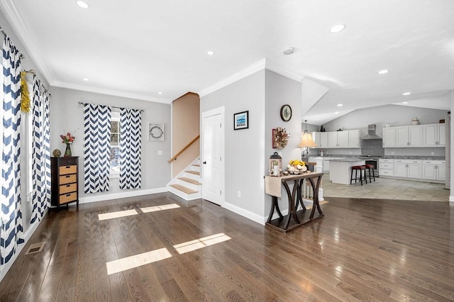 living area with baseboards, lofted ceiling, dark wood-style flooring, stairs, and crown molding