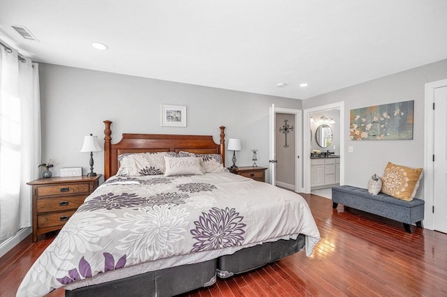 bedroom with dark wood-type flooring, recessed lighting, visible vents, and connected bathroom