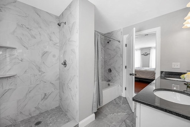 ensuite bathroom featuring marble finish floor, connected bathroom, a sink, and double vanity