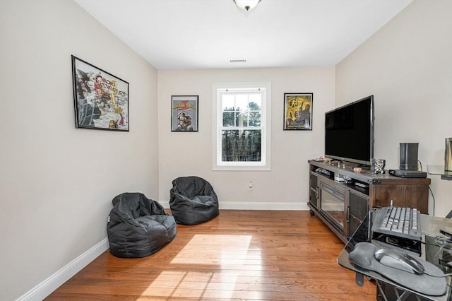 sitting room featuring visible vents, baseboards, and wood finished floors