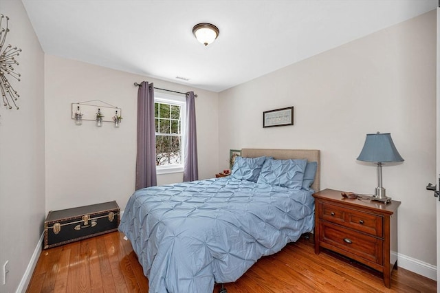 bedroom with baseboards and wood finished floors