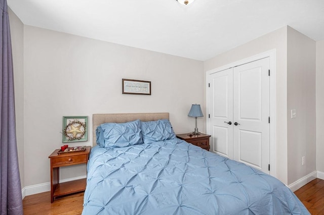 bedroom featuring a closet, baseboards, and wood finished floors