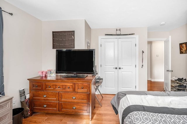 bedroom with light wood-type flooring and a closet