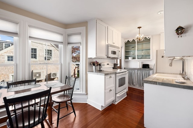 kitchen featuring white cabinetry, sink, tasteful backsplash, decorative light fixtures, and white appliances