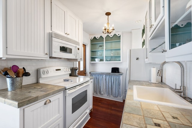 kitchen with white cabinetry, sink, white appliances, dark wood-type flooring, and pendant lighting