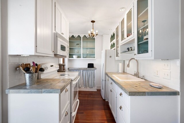 kitchen featuring sink, dark hardwood / wood-style floors, white cabinetry, white appliances, and decorative light fixtures