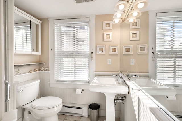 bathroom with baseboard heating, tile patterned floors, toilet, and a chandelier