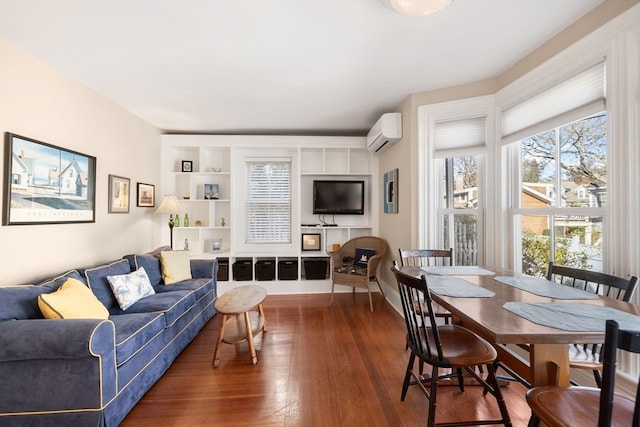 living room with built in shelves, hardwood / wood-style floors, and an AC wall unit