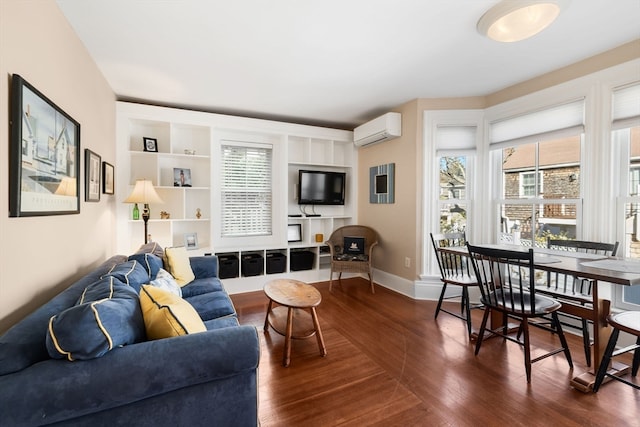 living room featuring built in shelves, dark hardwood / wood-style flooring, and a wall mounted air conditioner