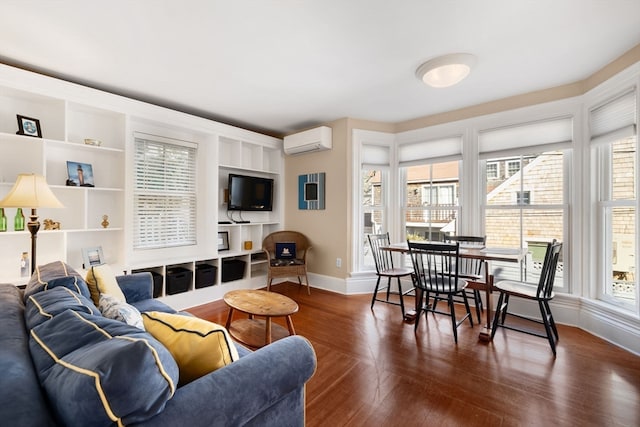 living room with a wall unit AC, dark wood-type flooring, a healthy amount of sunlight, and built in features