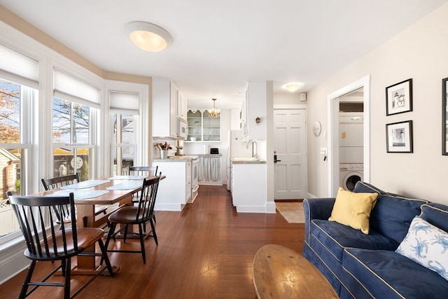 interior space featuring stacked washer / drying machine and sink