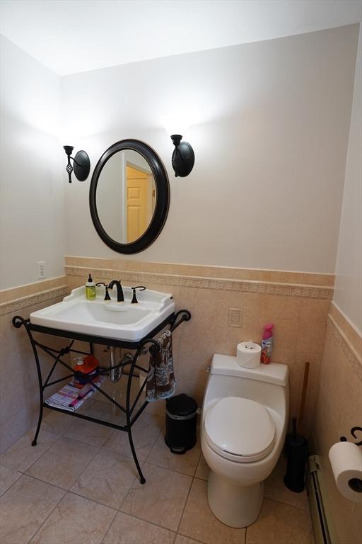 42 Wall St, Middleboro, MA 02346 - half bath with wainscoting, tile walls, tile patterned floors, and baseboard heating