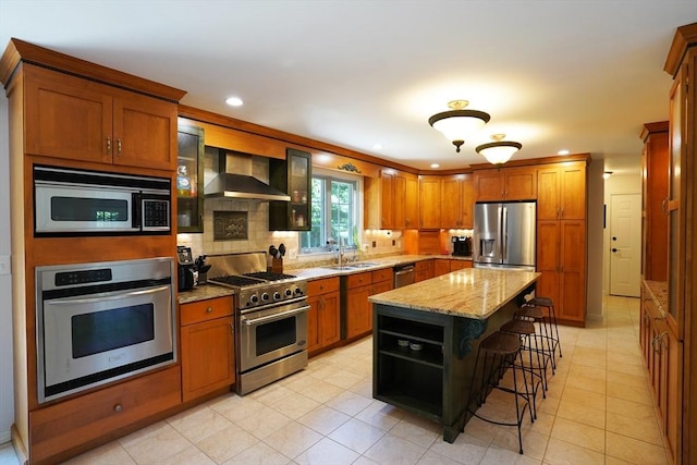 42 Wall St, Middleboro, MA 02346 - kitchen featuring appliances with stainless steel finishes, wall chimney range hood, a breakfast bar area, recessed lighting, and brown cabinetry