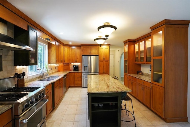 42 Wall St, Middleboro, MA 02346 - kitchen with stainless steel appliances, wall chimney range hood, brown cabinetry, and decorative backsplash