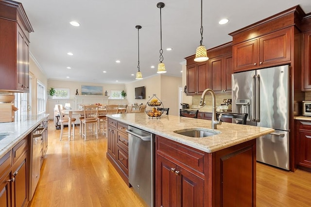 kitchen featuring appliances with stainless steel finishes, a sink, light wood-style flooring, decorative backsplash, and recessed lighting