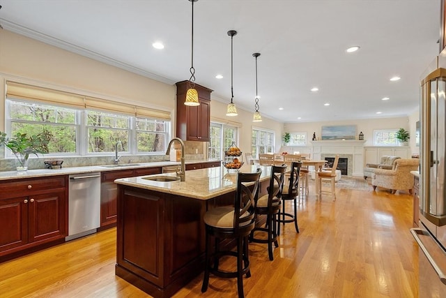 kitchen featuring a sink, light stone counters, dark brown cabinets, light wood-style floors, and recessed lighting
