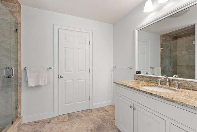 full bathroom featuring a shower stall, baseboards, and vanity