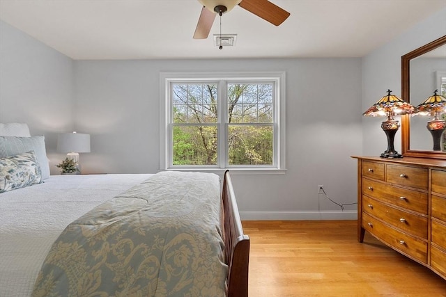 bedroom with light wood-style flooring, baseboards, and a ceiling fan