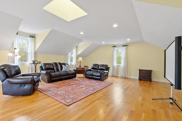 living room with light wood-style flooring, plenty of natural light, vaulted ceiling, and baseboards