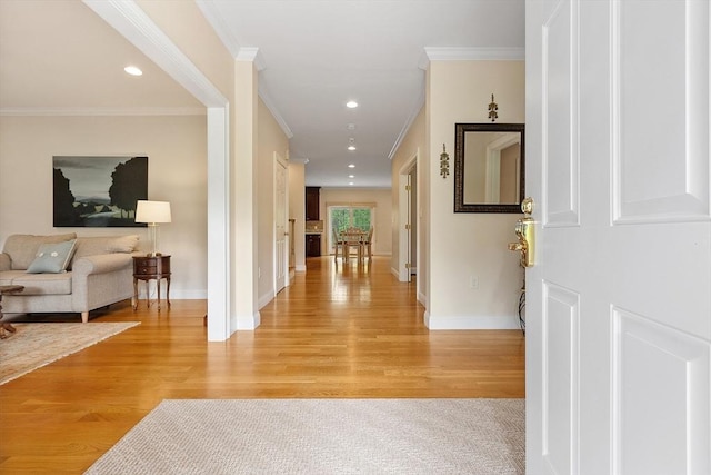 hallway with light wood finished floors, baseboards, crown molding, and recessed lighting